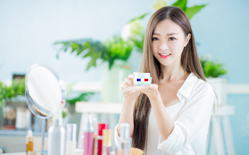 Femme chinoise qui tient un produit cosmétique Made in France